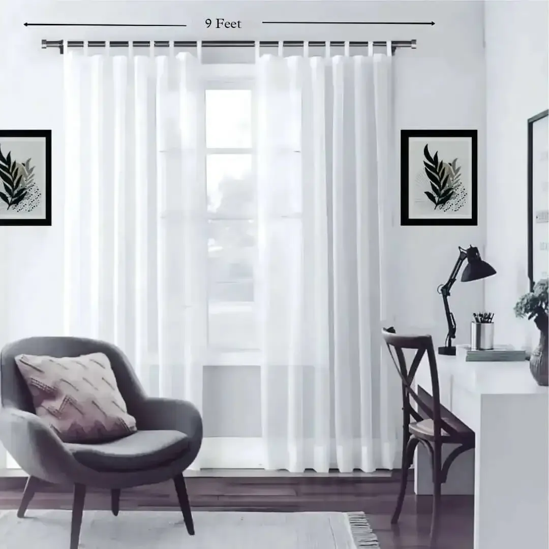 9 feet adjustable curtain rod 9 feet adjustable curtain rod - Stylish living room with flowing sheer curtains on a chrome finish adjustable curtain rod 9 feet set, paired with a single seater, and a table —creating a chic, inviting ambiance. Text highlight '9 feet'