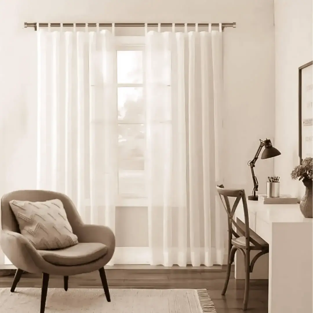 living room curtain rod set curtain pole for living room - Stylish living room with flowing sheer curtains on a bronze colour curtain rod, paired with a single seater, and a table —creating a chic, inviting ambiance.