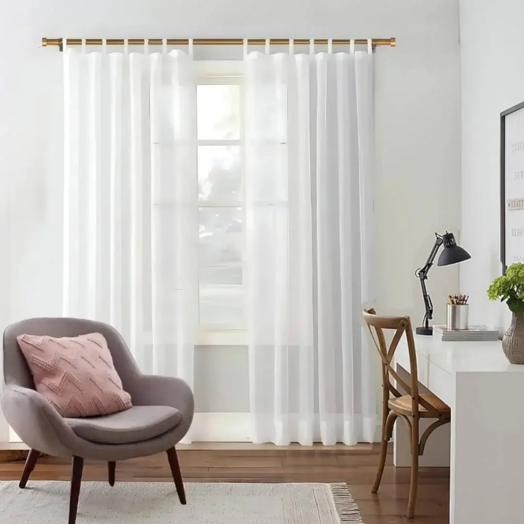 gold curtain rod for living room gold curtain rod for living room - Stylish living room with flowing tab top sheer curtains on a gold adjustable curtain rod, paired with a single seater, and a table —creating a chic, inviting ambiance.